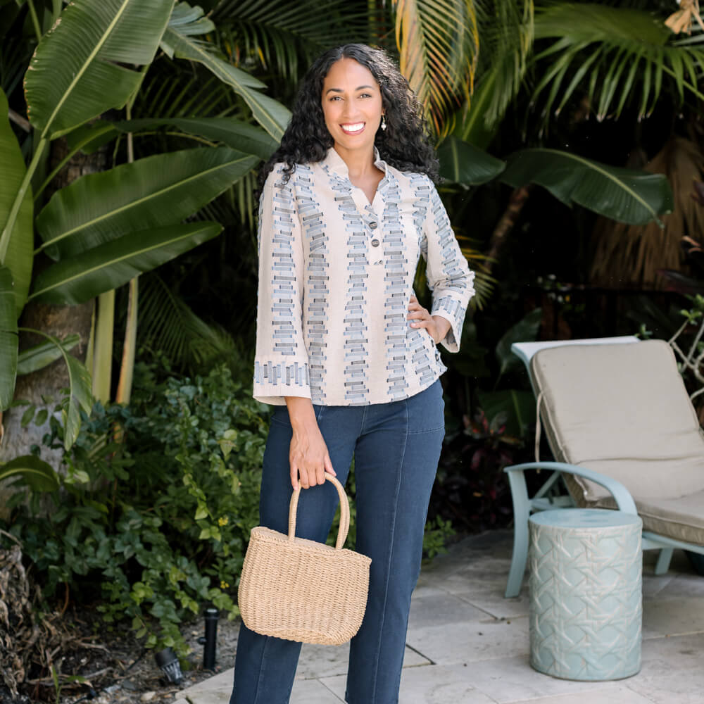 Woman wearing a Habitat Blouse and pants with greenery behind her