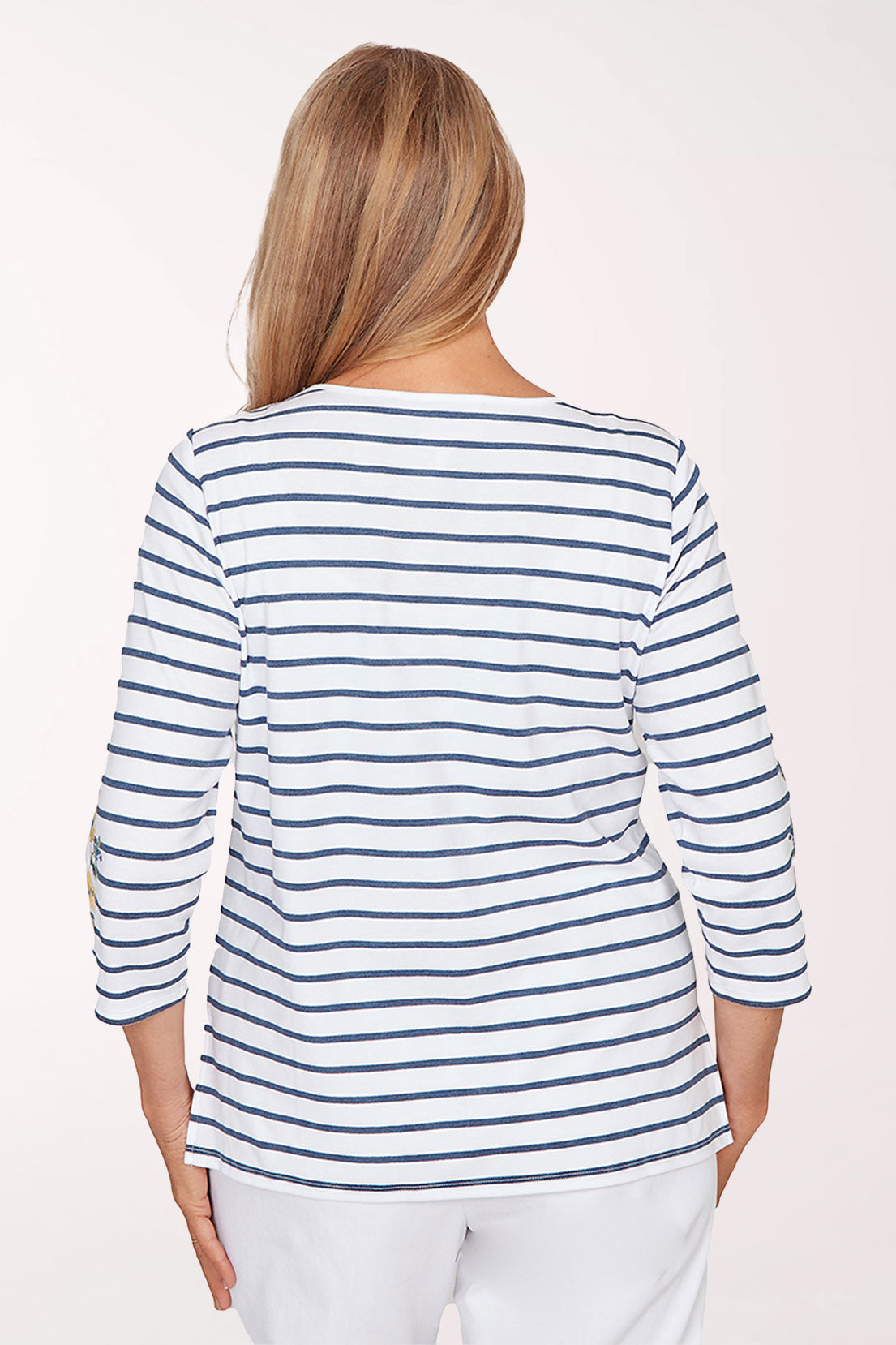 Woman wearing a blue and white striped shirt with floral sleeves on a white background