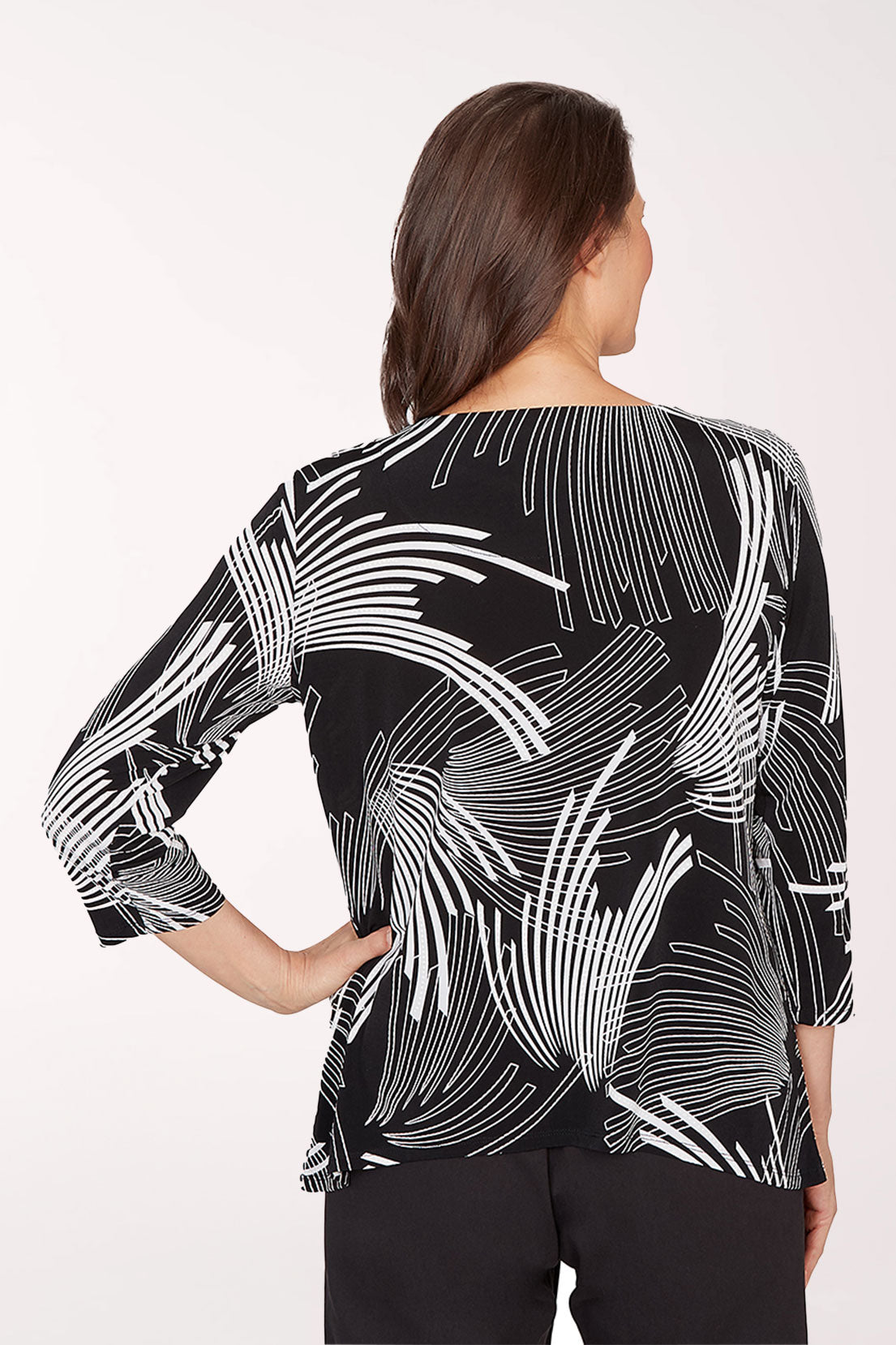Woman wearing a black and white patterned top on a white background