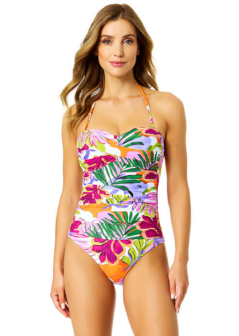 Woman wearing a colorful tropical print swimsuit on a white background