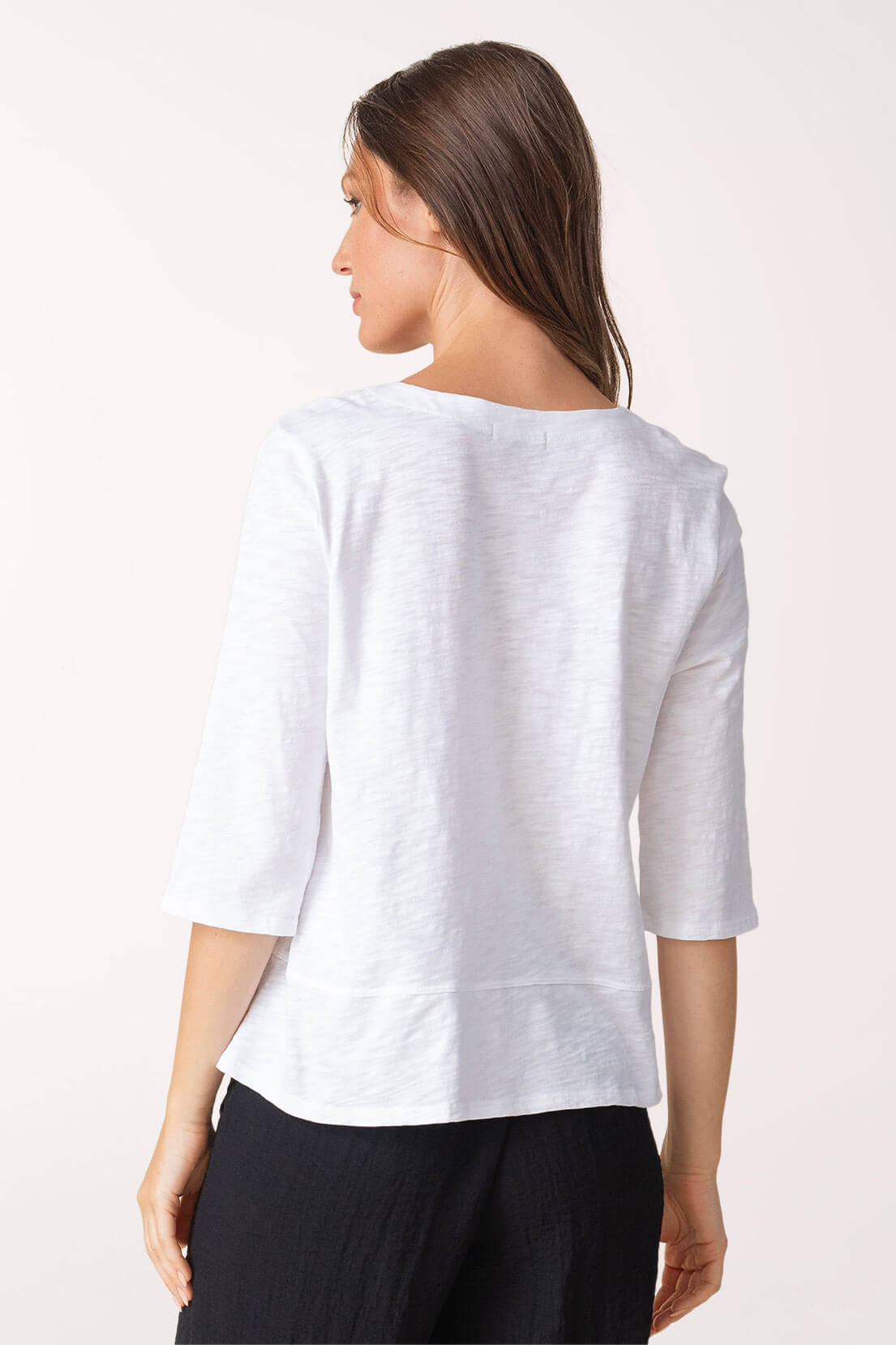 Woman wearing a white blouse with a plain background