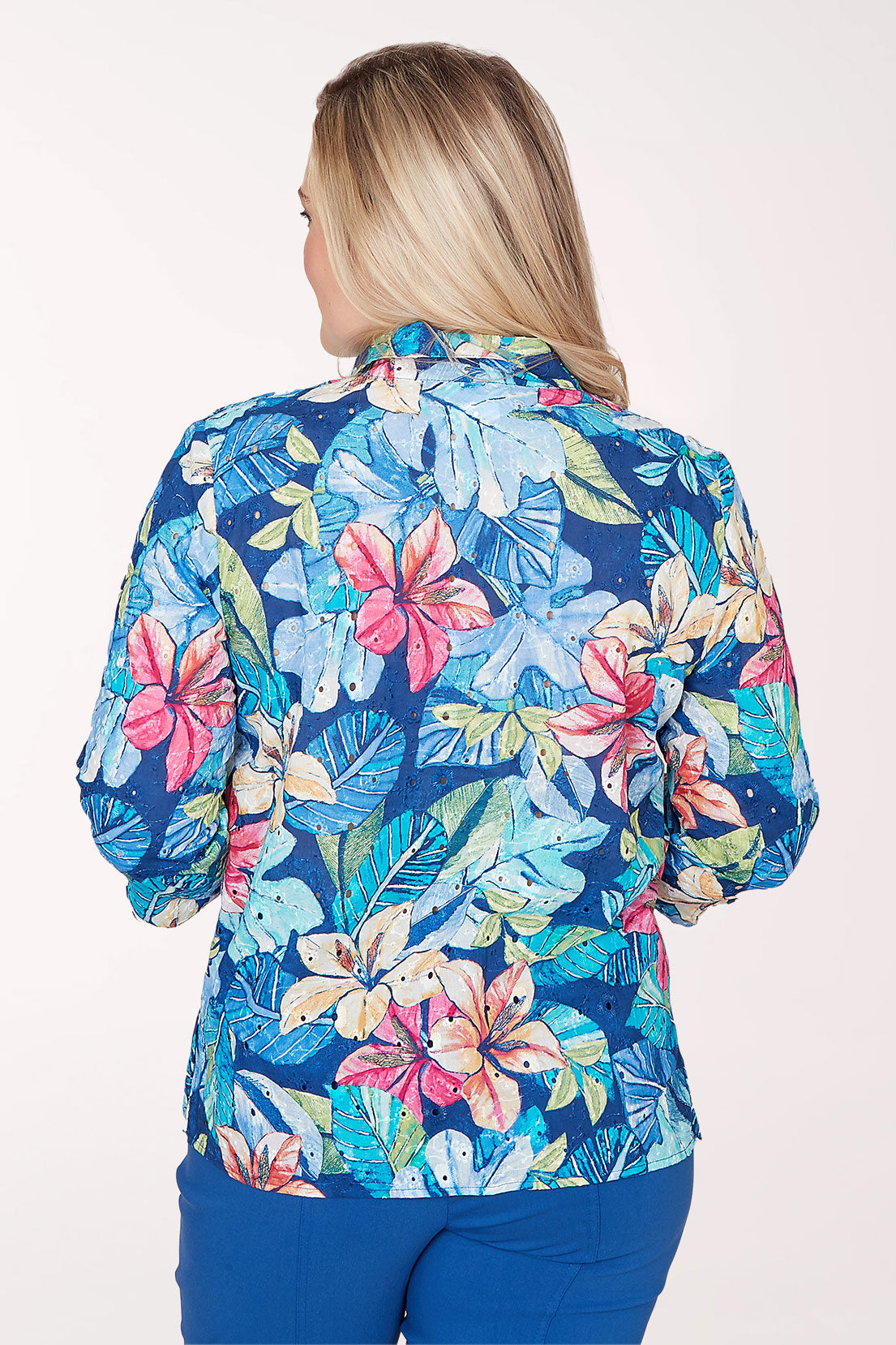 Woman wearing a colorful floral blouse with a white background