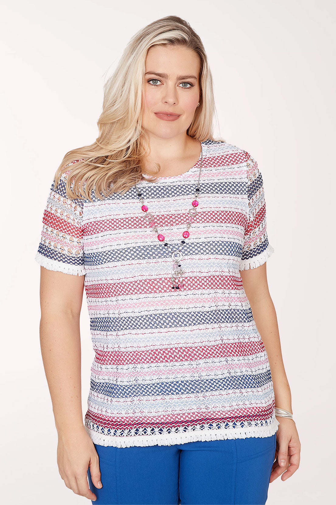 Woman wearing a patterned top with buttons on a white background