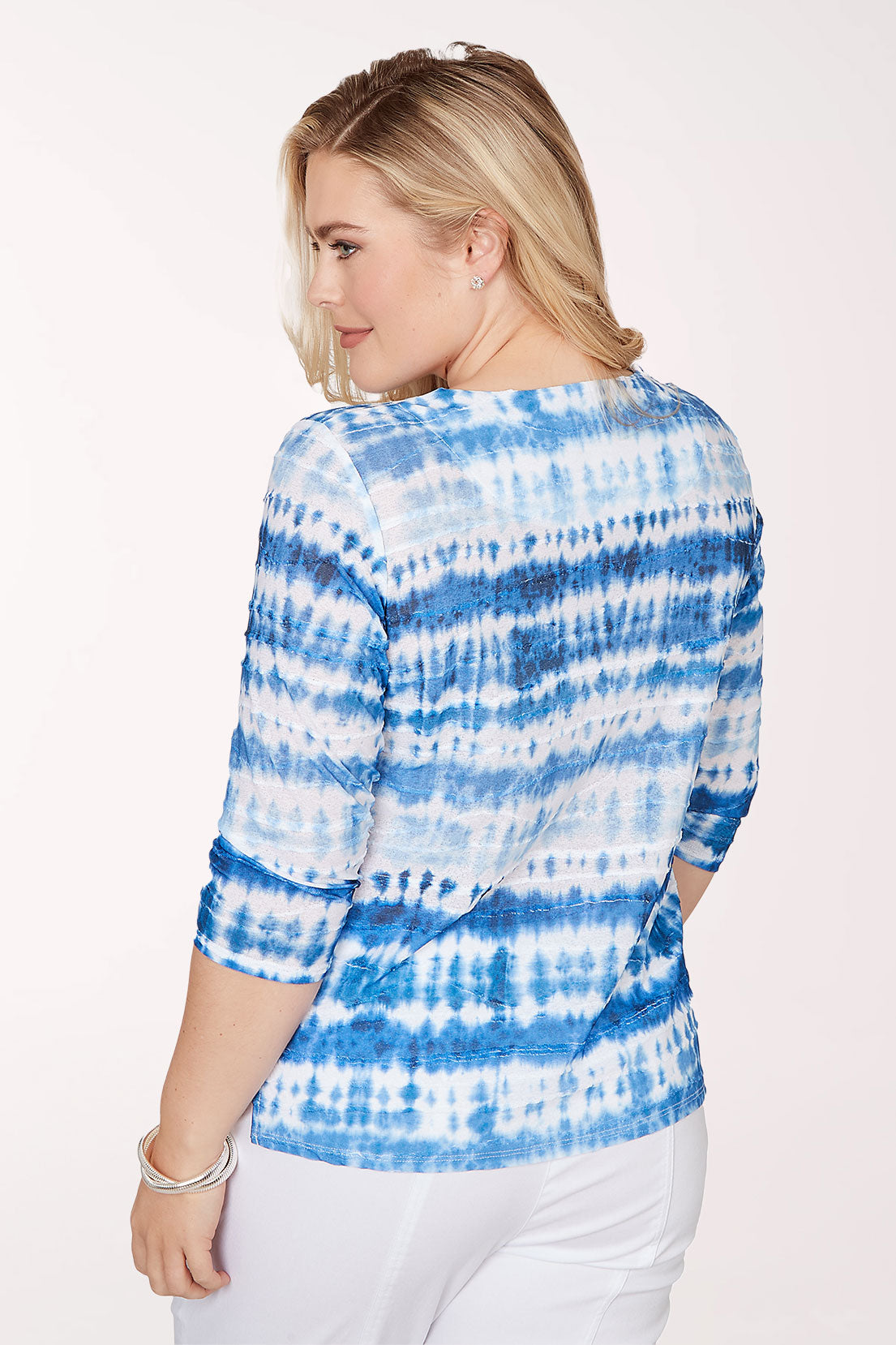 Woman wearing a blue and white tie-dye sweater on a white background