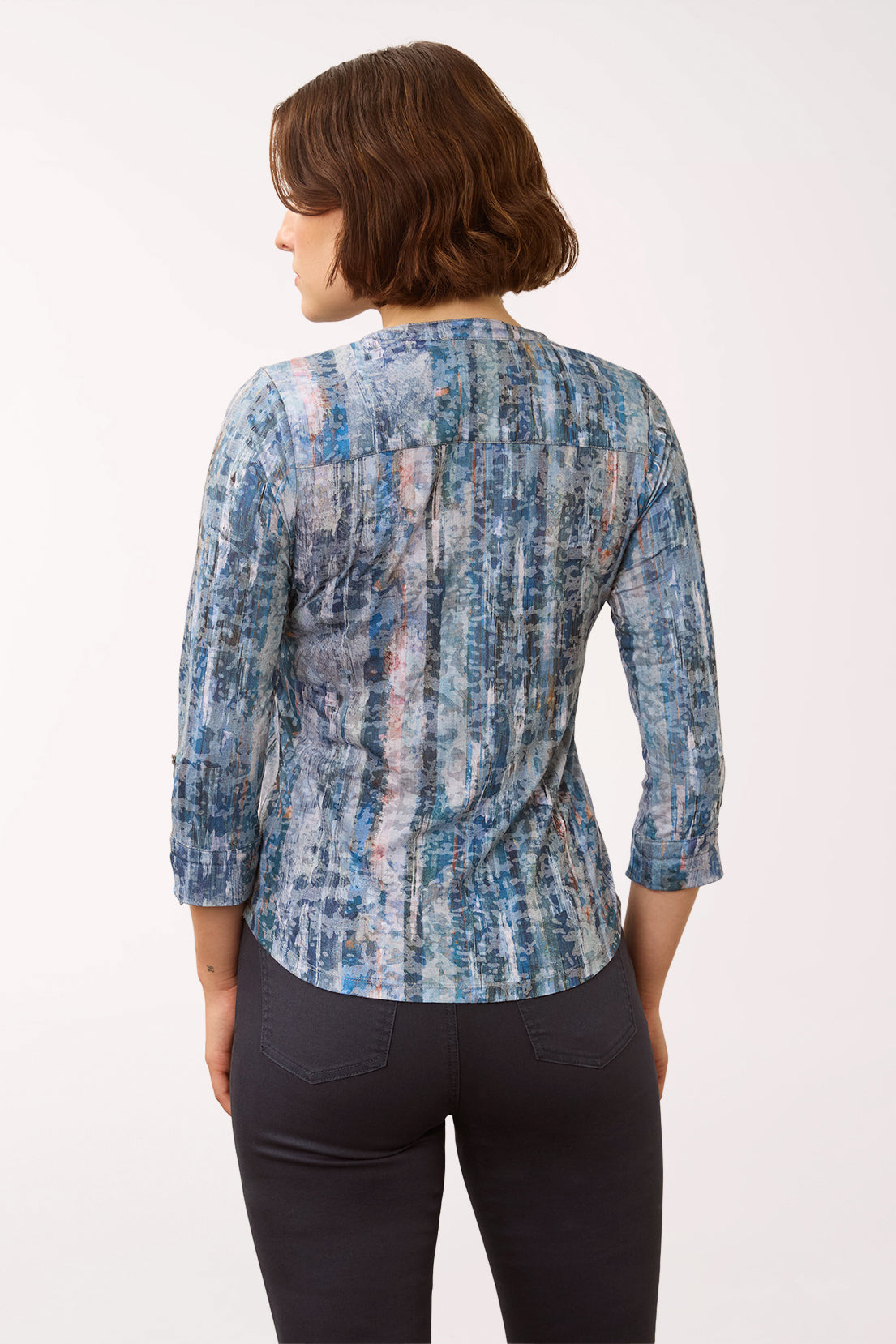 Woman wearing a 3/4 sleeve blue triple button henley top