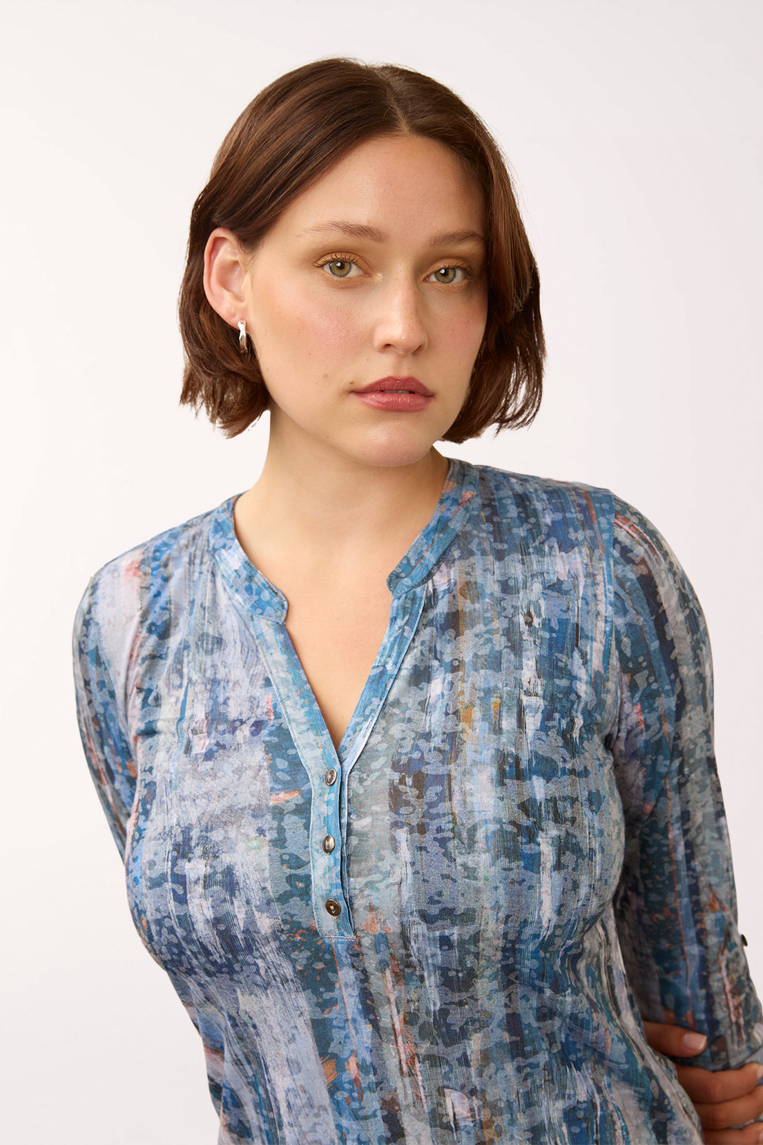 Woman wearing a 3/4 sleeve blue triple button henley top