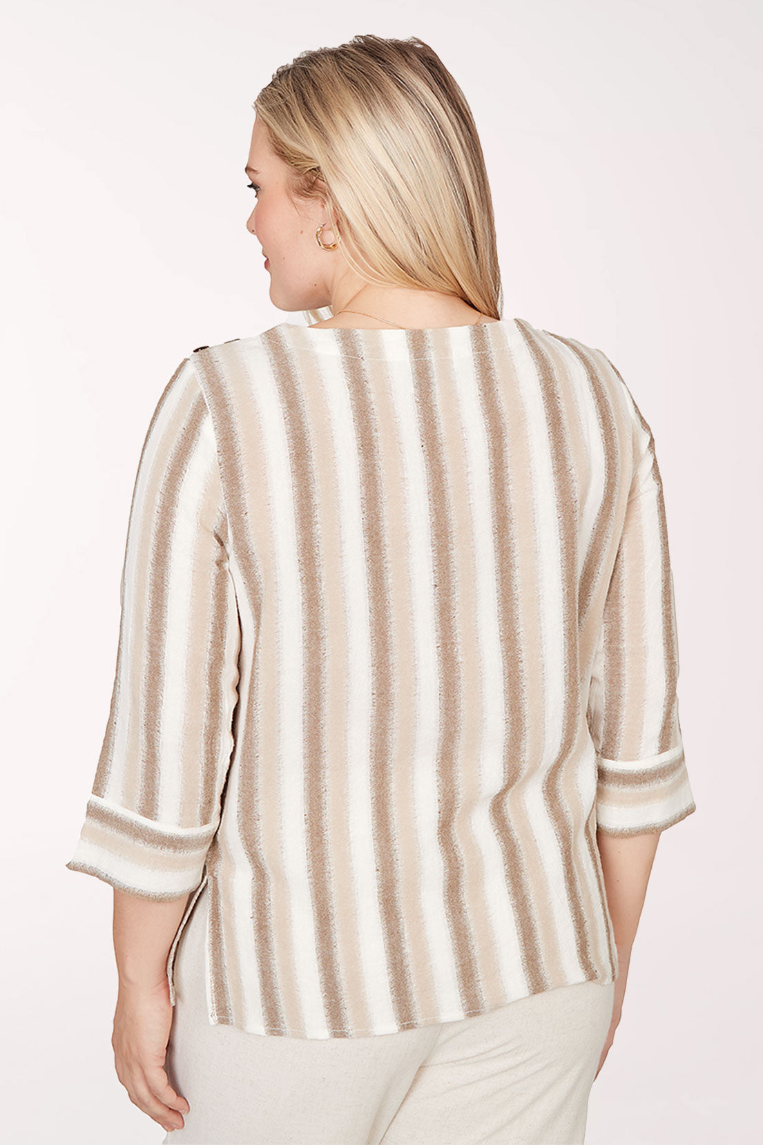 Woman wearing a beige and brown striped top on a white background