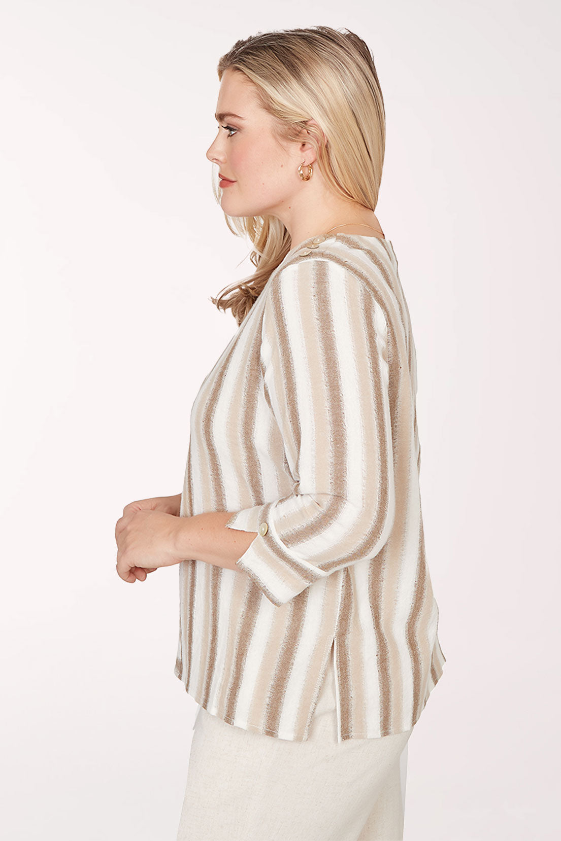 Woman wearing a beige and brown striped top on a white background