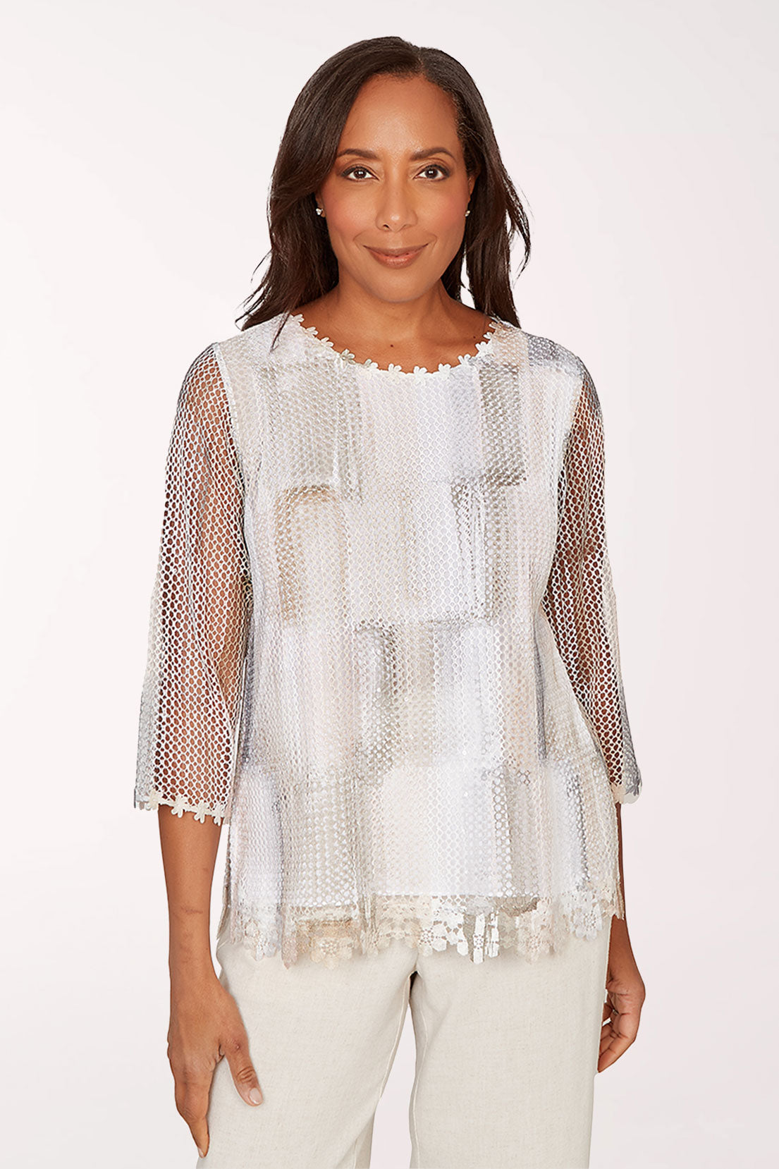 Woman wearing a sheer white top with a subtle pattern on a white background