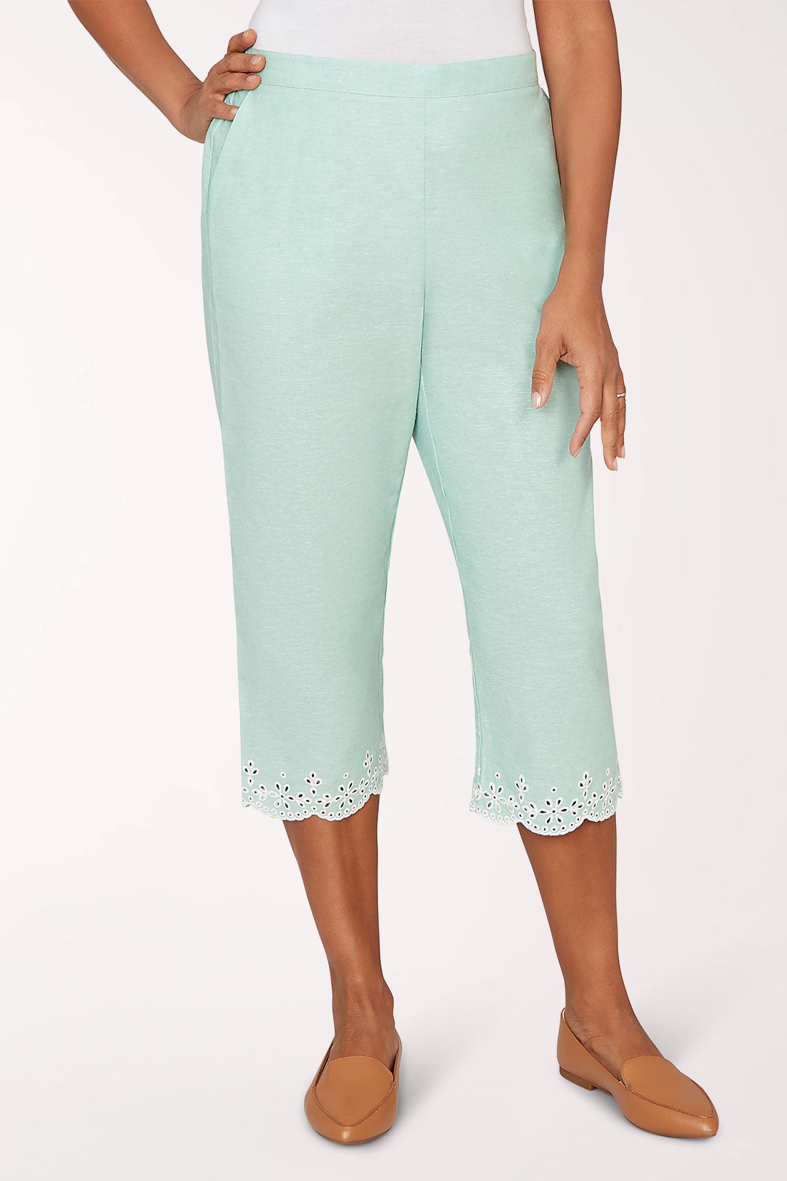 Mint green capri pants with lace trim worn by a person on a white background