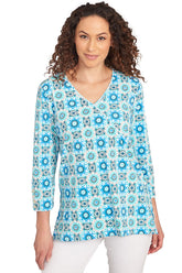 A front shot of a model wearing a blue and white medallion surplice top with 3/4 sleeves and a V-neck.