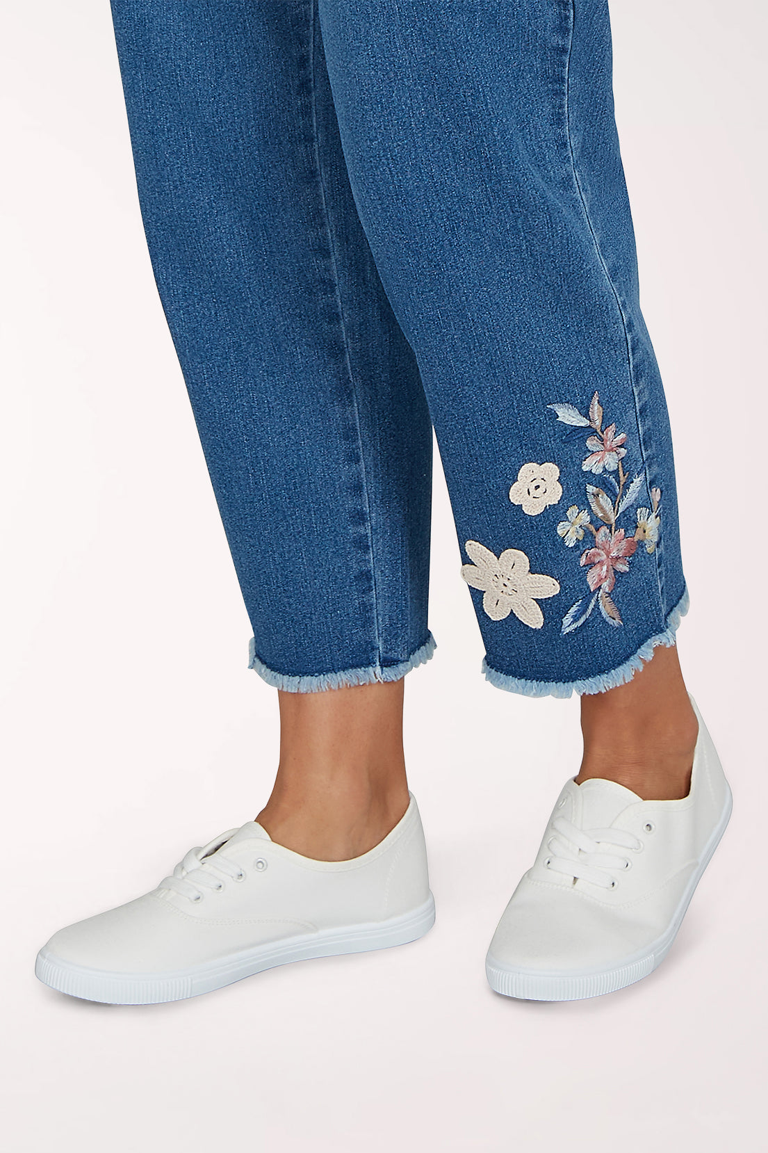 Woman wearing a denim crop pant with a floral design