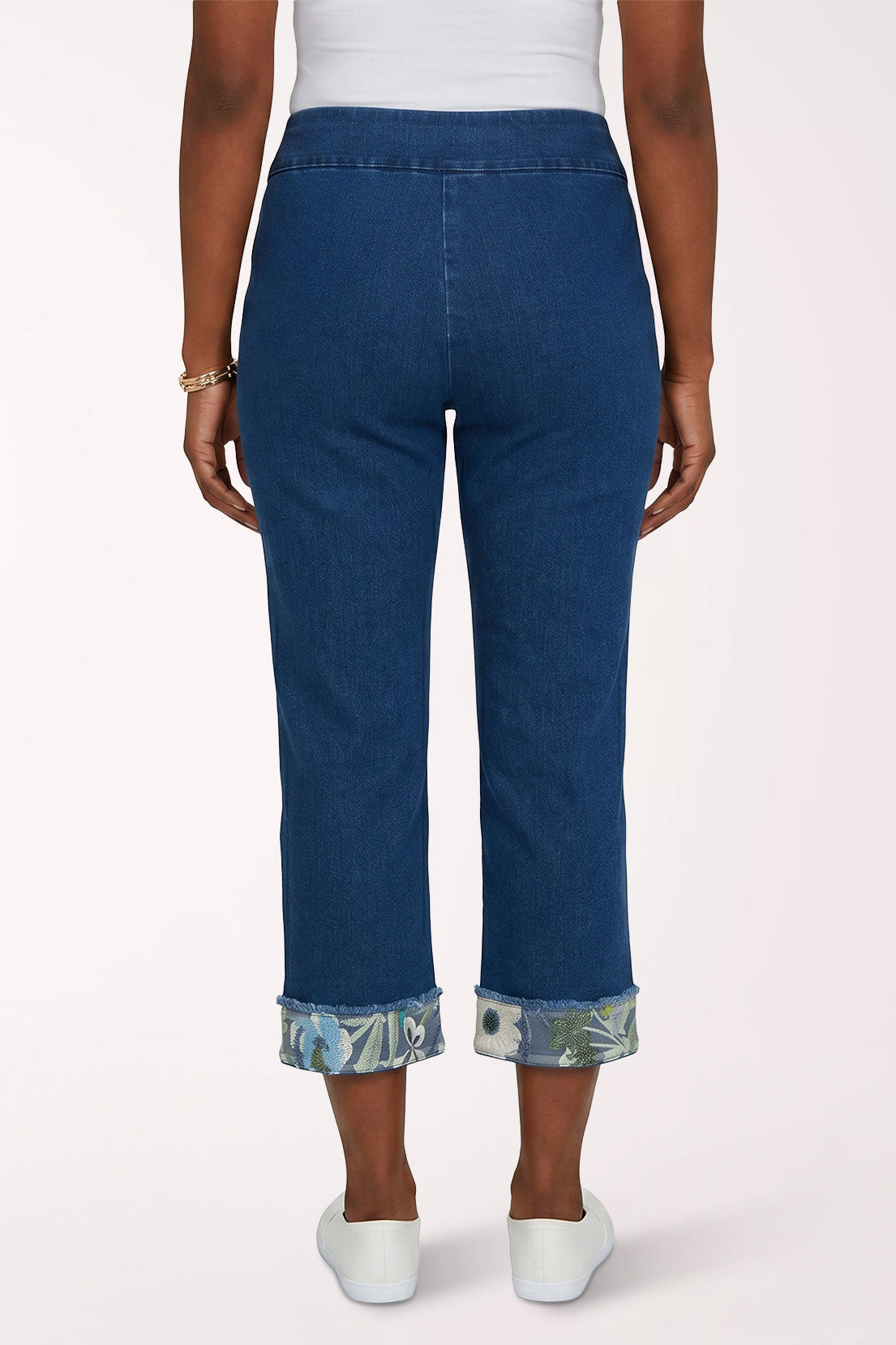 Woman wearing a denim cropped pant with floral hem