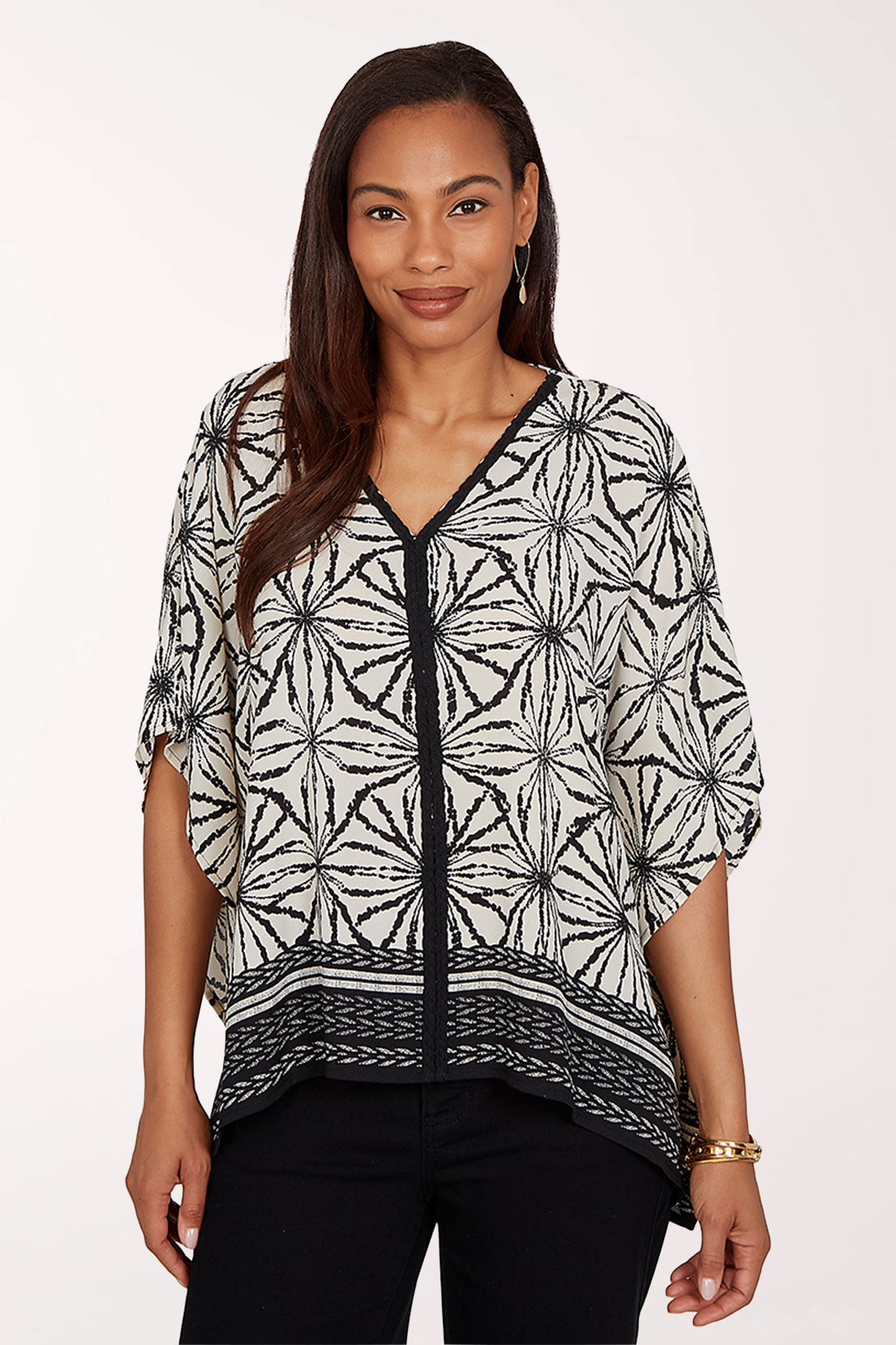 Woman wearing a black and white patterned top on a white background