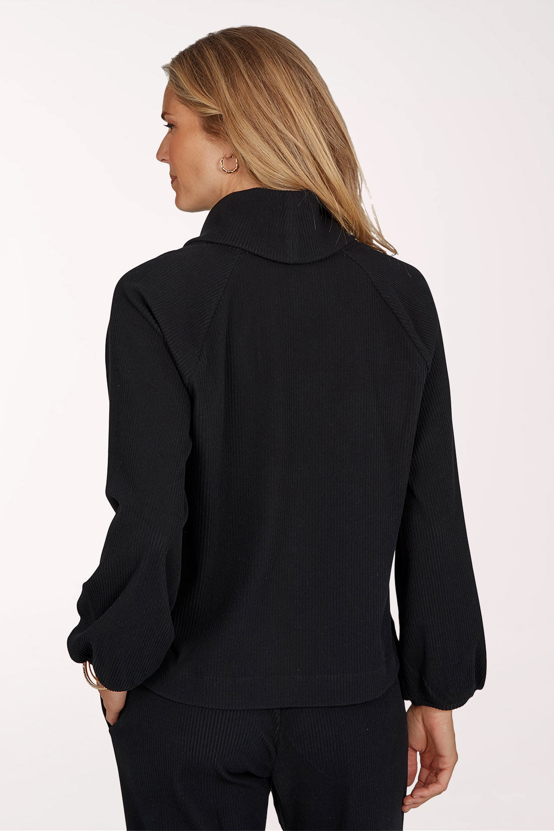 Woman wearing a black long sleeve cowl neck top