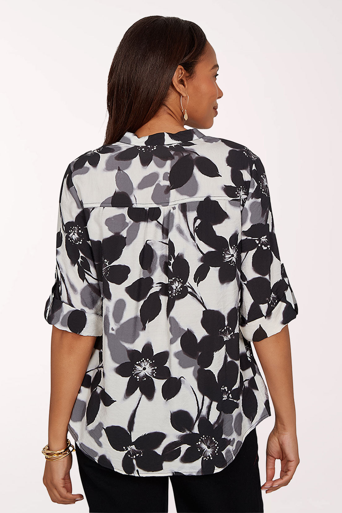 Woman wearing a black and white floral blouse on a white background