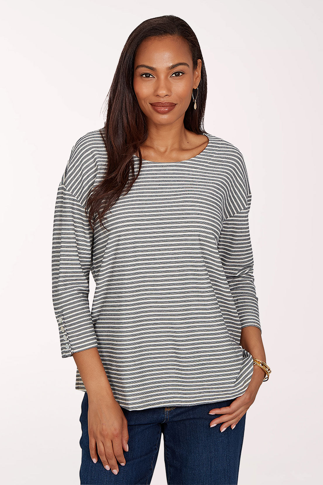 Woman wearing a striped black and white shirt and jeans on a white background