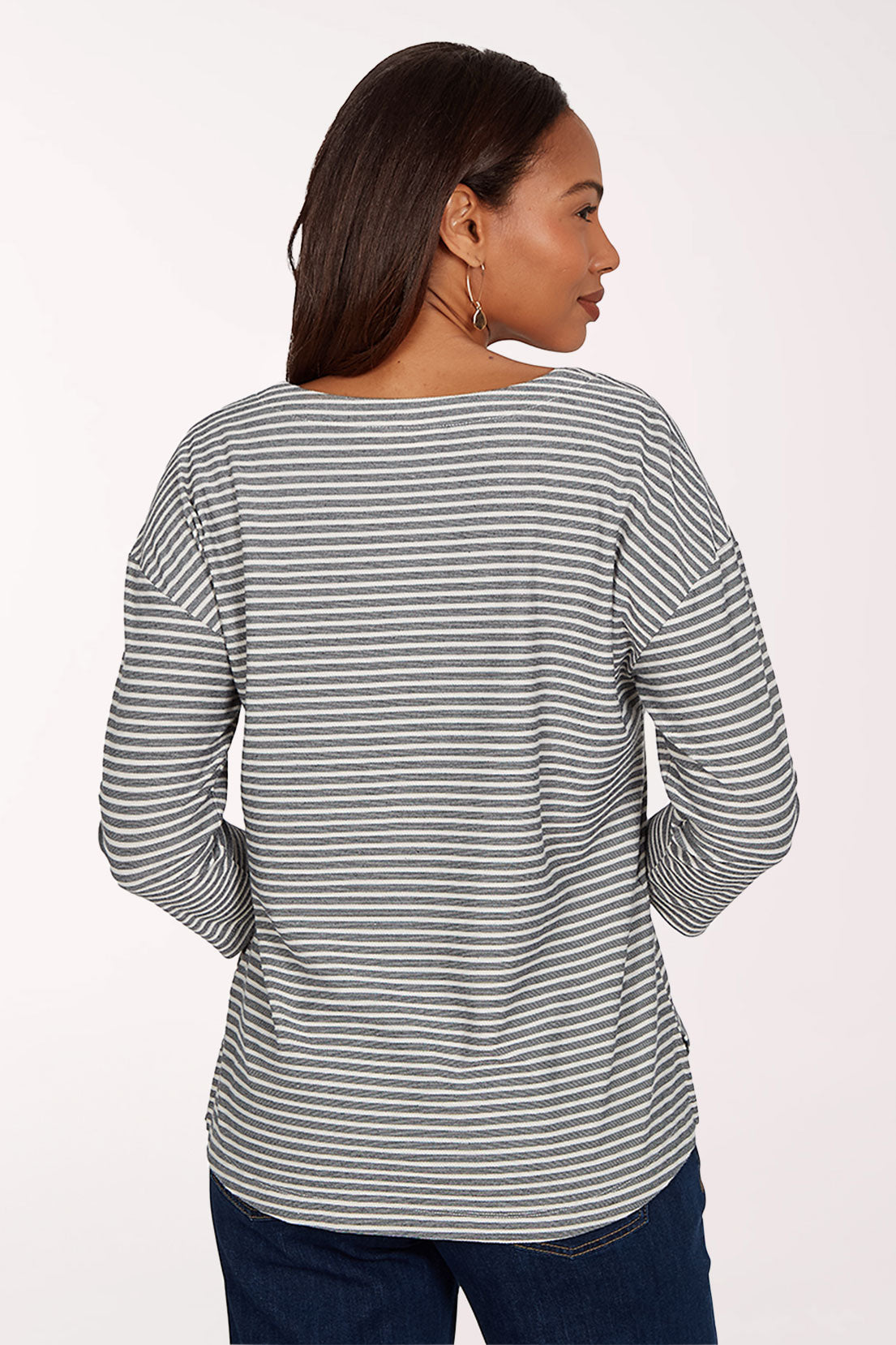 Woman wearing a striped black and white shirt and jeans on a white background
