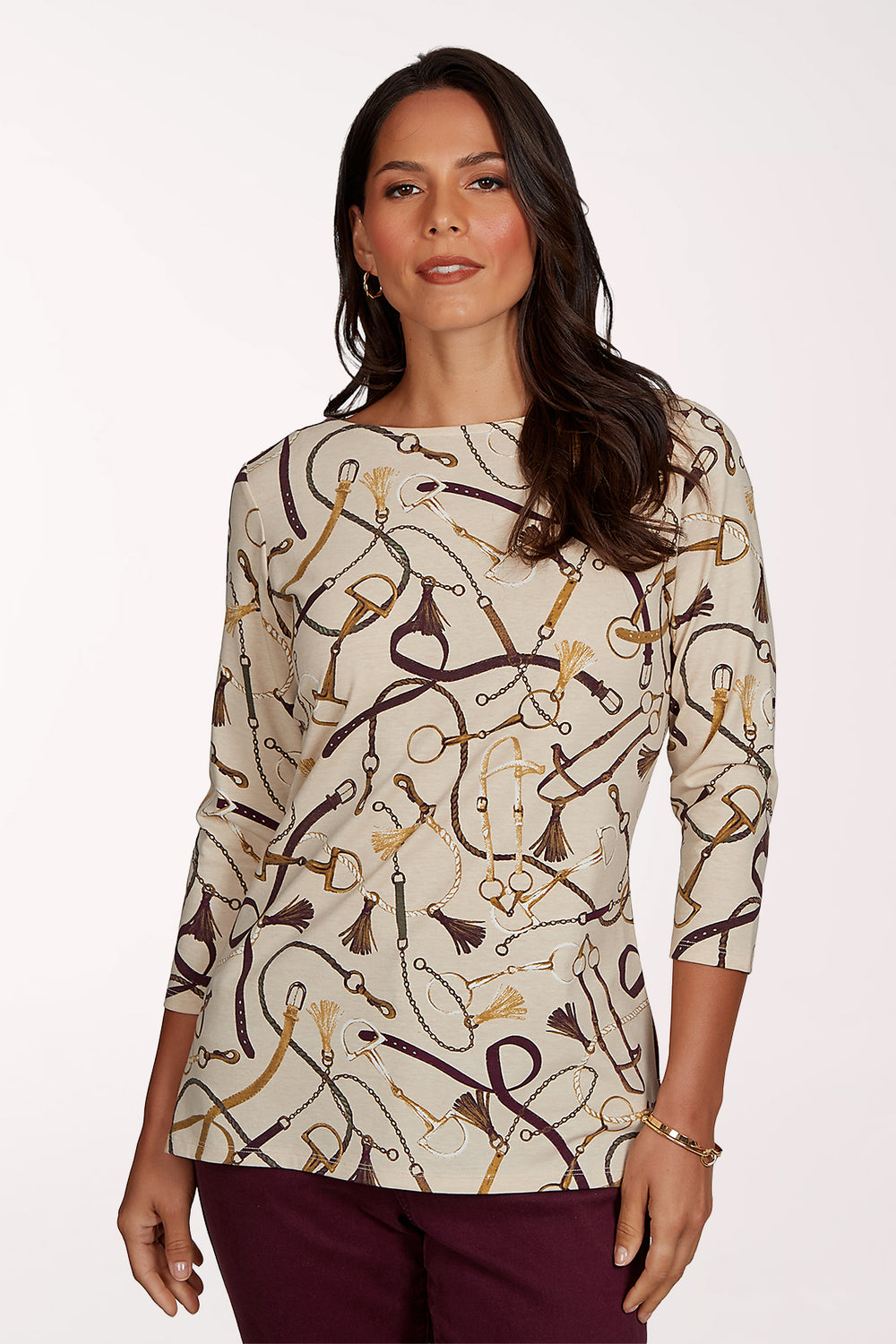 Woman wearing a 3/4 sleeve beige top with an equestrian pattern