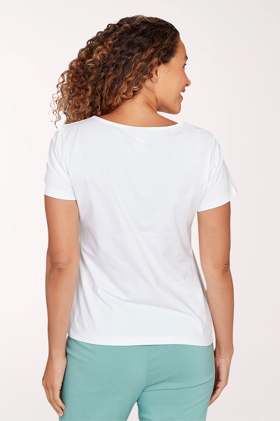 Woman wearing a white shirt with a front lace-up design on a light pink background