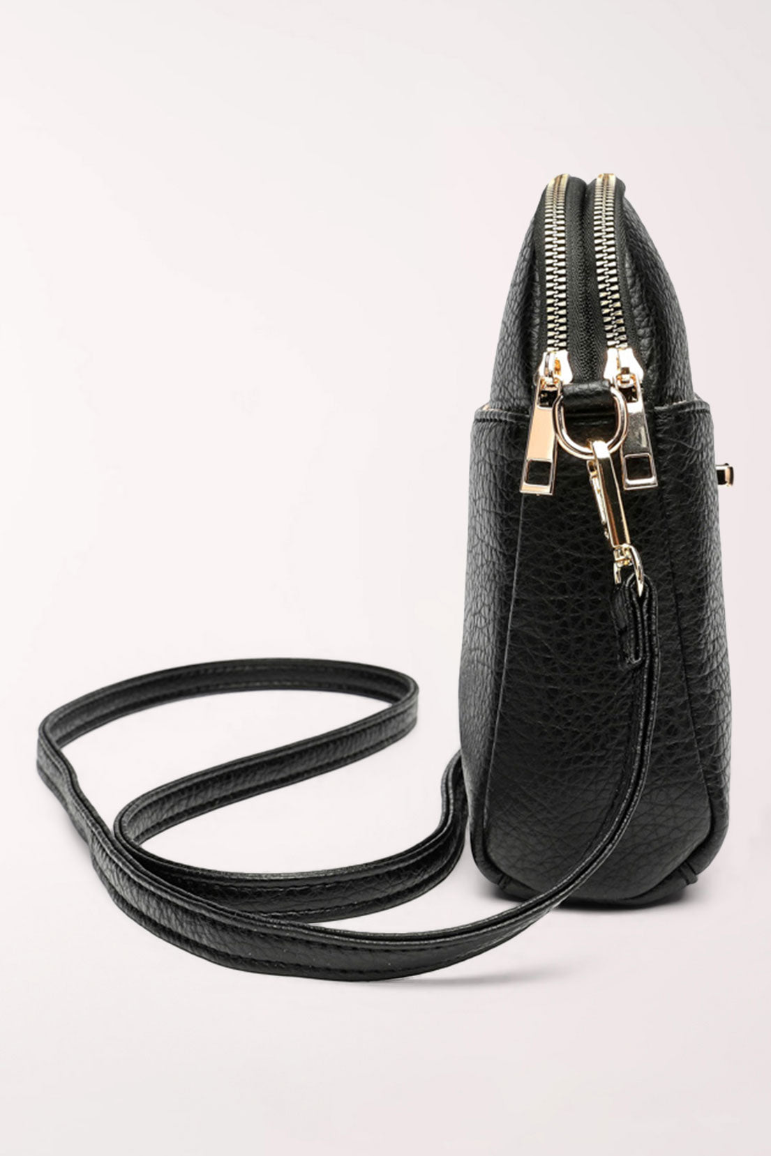 Side view of the black 22 Tote Four-Pocket Crossbody Bag showing the slim profile, double zipper top and gold strap clip.