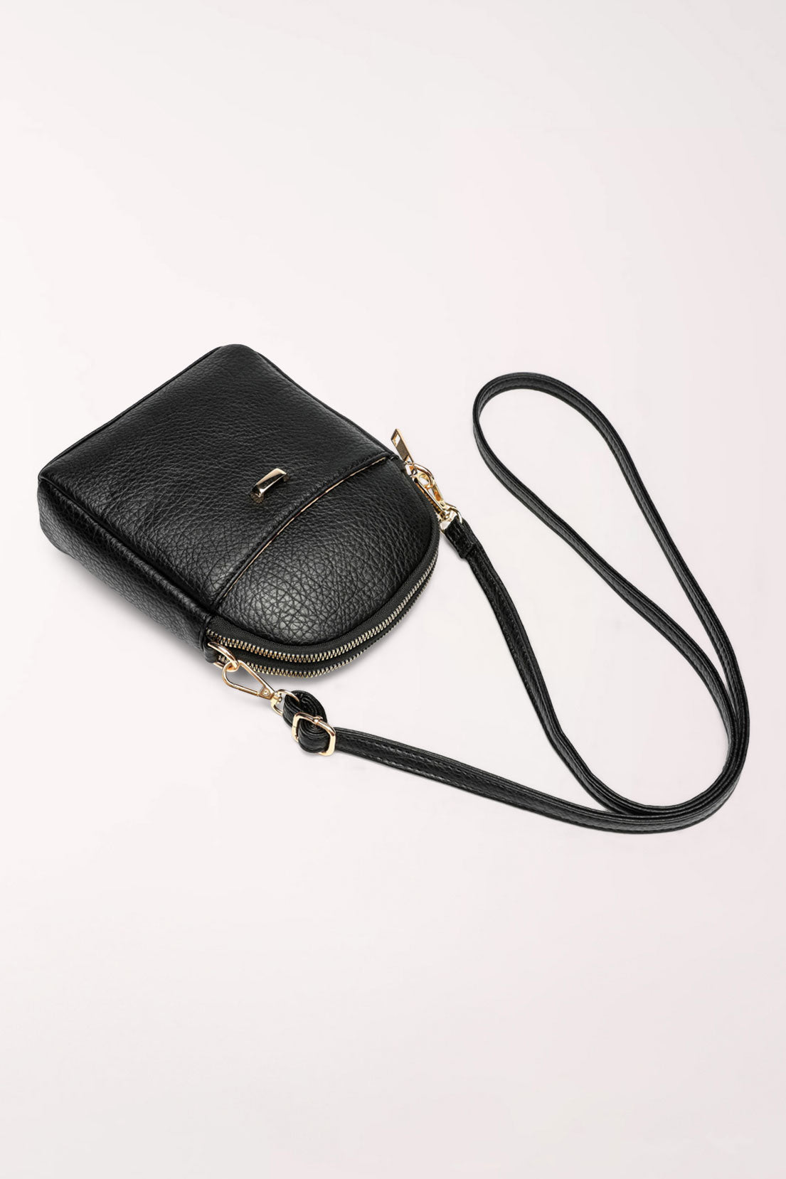 The black 22 Tote Four-Pocket Crossbody Bag lying flat with its strap draped beside it.