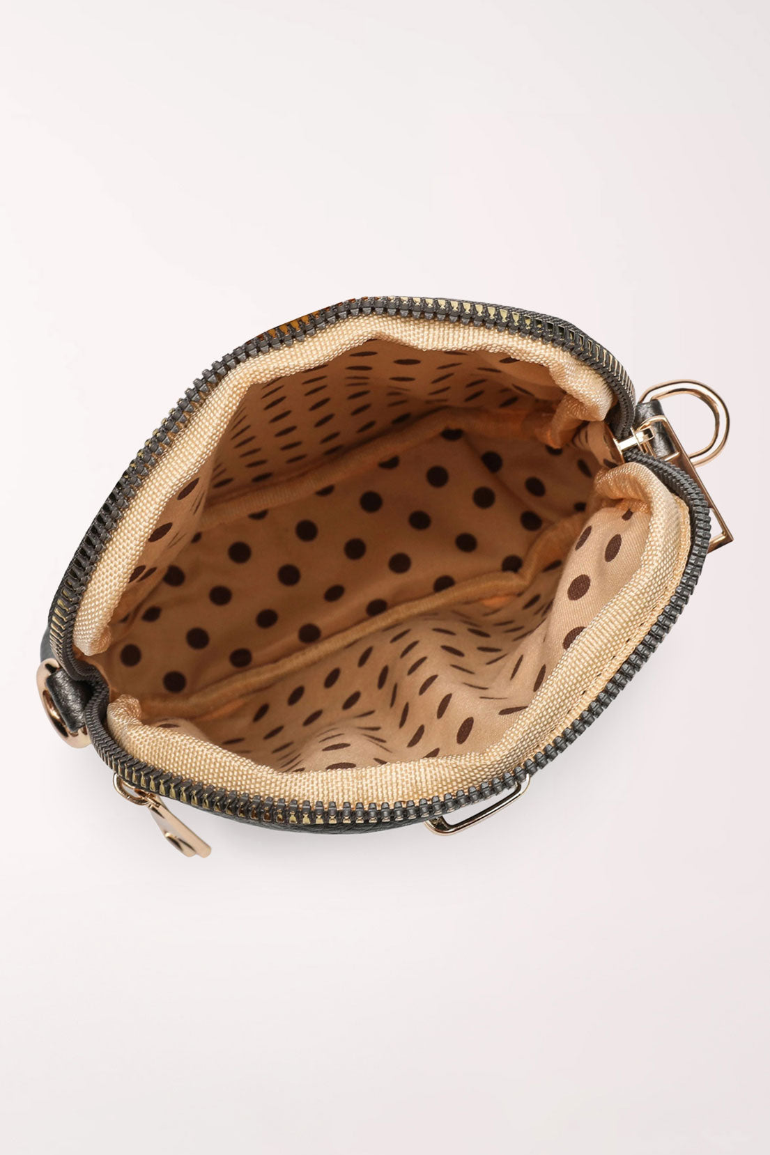 Top view of the pewter 22 Tote Three-Pocket Crossbody Bag unzipped to show the tan lining with brown polka dots.