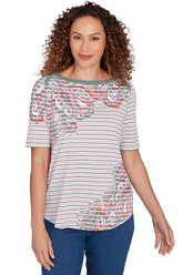 A front shot of a model wearing a bay leaf patterned shirt with blue jeans.