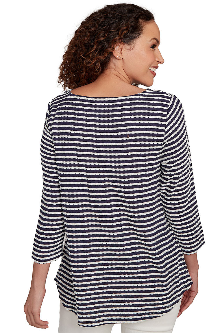 A back shot of a model wearing a navy and white striped shirt on a white background
