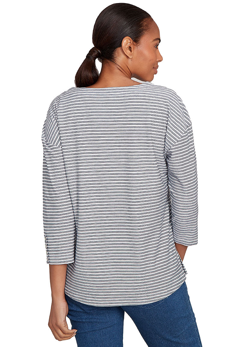 A back shot of a model wearing a gray and white striped long-sleeve top with blue jeans on a white background