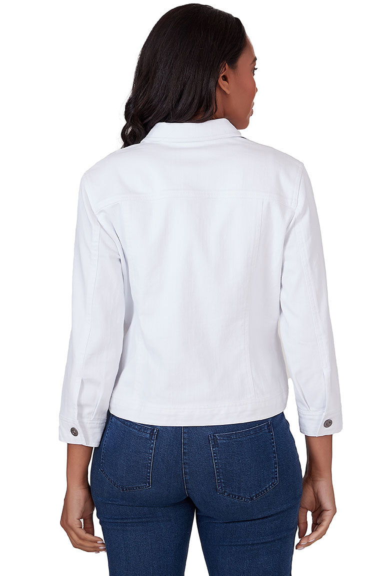 A back shot of a model wearing a white button-front denim jacket with a foldover collar, 3/4-length sleeves with buttoned cuffs, and dual buttoned chest pockets.