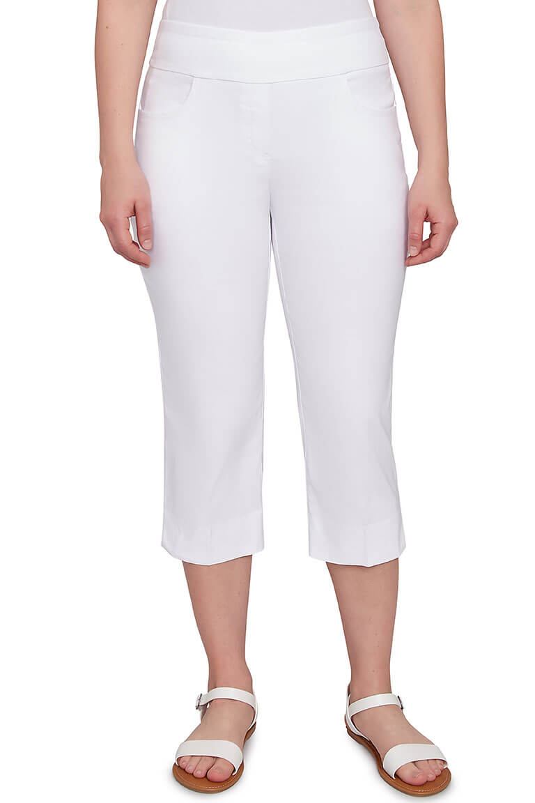 A front shot of a model wearing a white-colored pull-on silky capri pant with an elasticized waistband, dual front and back pockets, and a straight hemline with side slits.