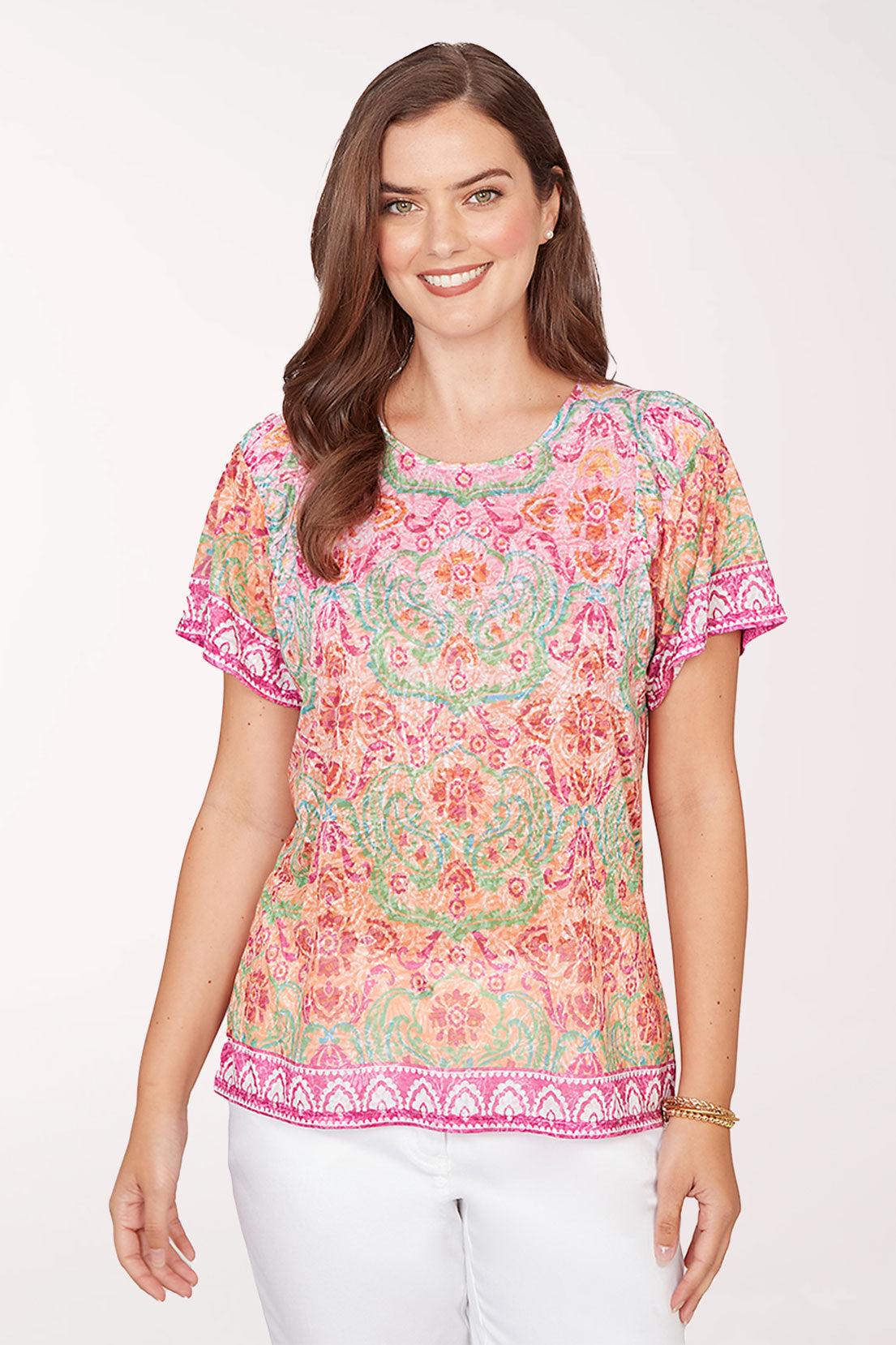 Woman wearing a colorful patterned top on a white background