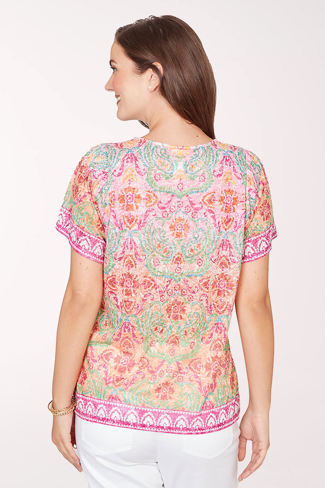 Woman wearing a colorful patterned top on a white background