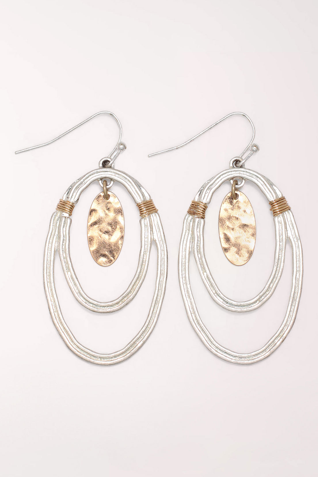 Pair of Periwinkle Silver and Gold Oval Drop Earrings on silver-tone French hooks: two nested hammered silver ovals with gold coil wraps at the top and a hammered gold oval disc dangling in the center.