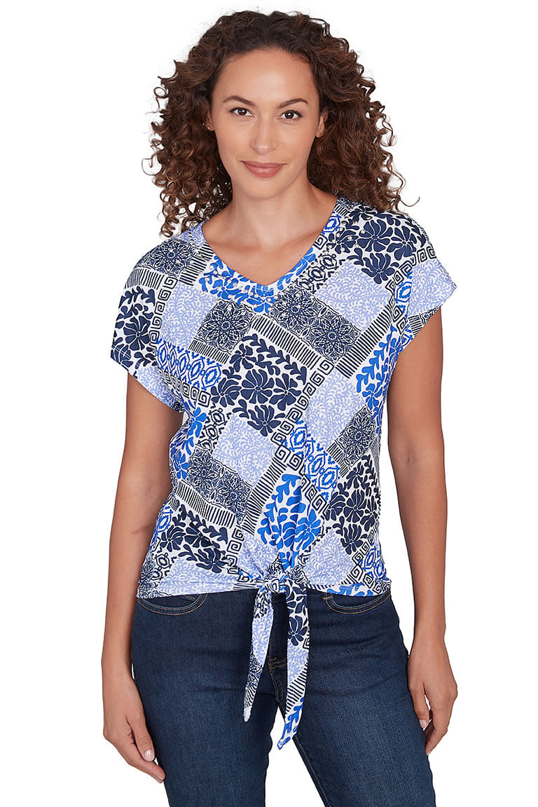A front shot of a model wearing a blue and multicolor crinkle textured v-neck knit top with dolman cap sleeves and a tie-front hemline.
