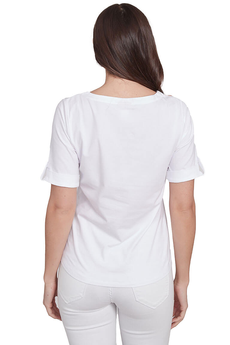 A back shot of a model wearing a white top with tropical leaf prints and short sleeves. The top features a notched neck and metallic closure on the neckline.