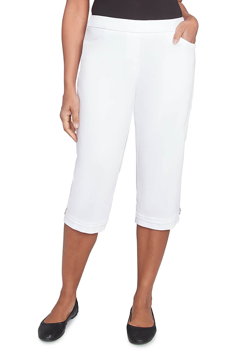 A pair of white pleated hem capri pants with a stretch waistband, dual front pockets, and button detail on the hemline.