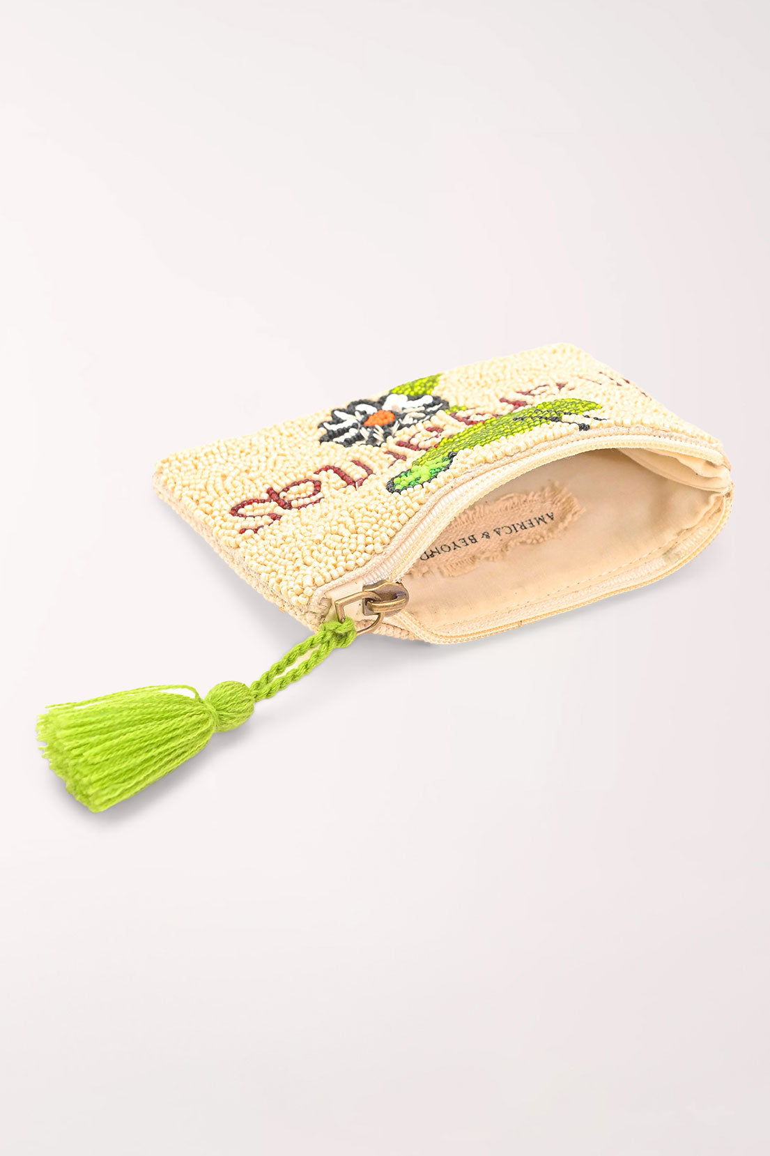A small cream-colored beaded pouch with a bright green tassel and embroidered floral details, a margarita glass, and the word "margaritas" shown on a light off-white background.
