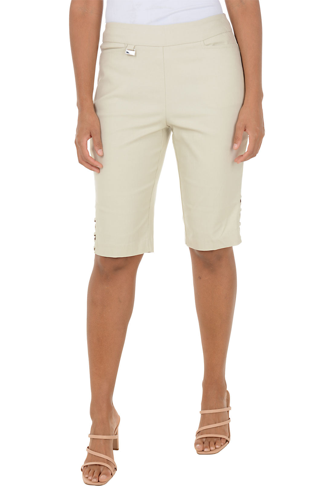Person wearing beige bermuda shorts on a white background.