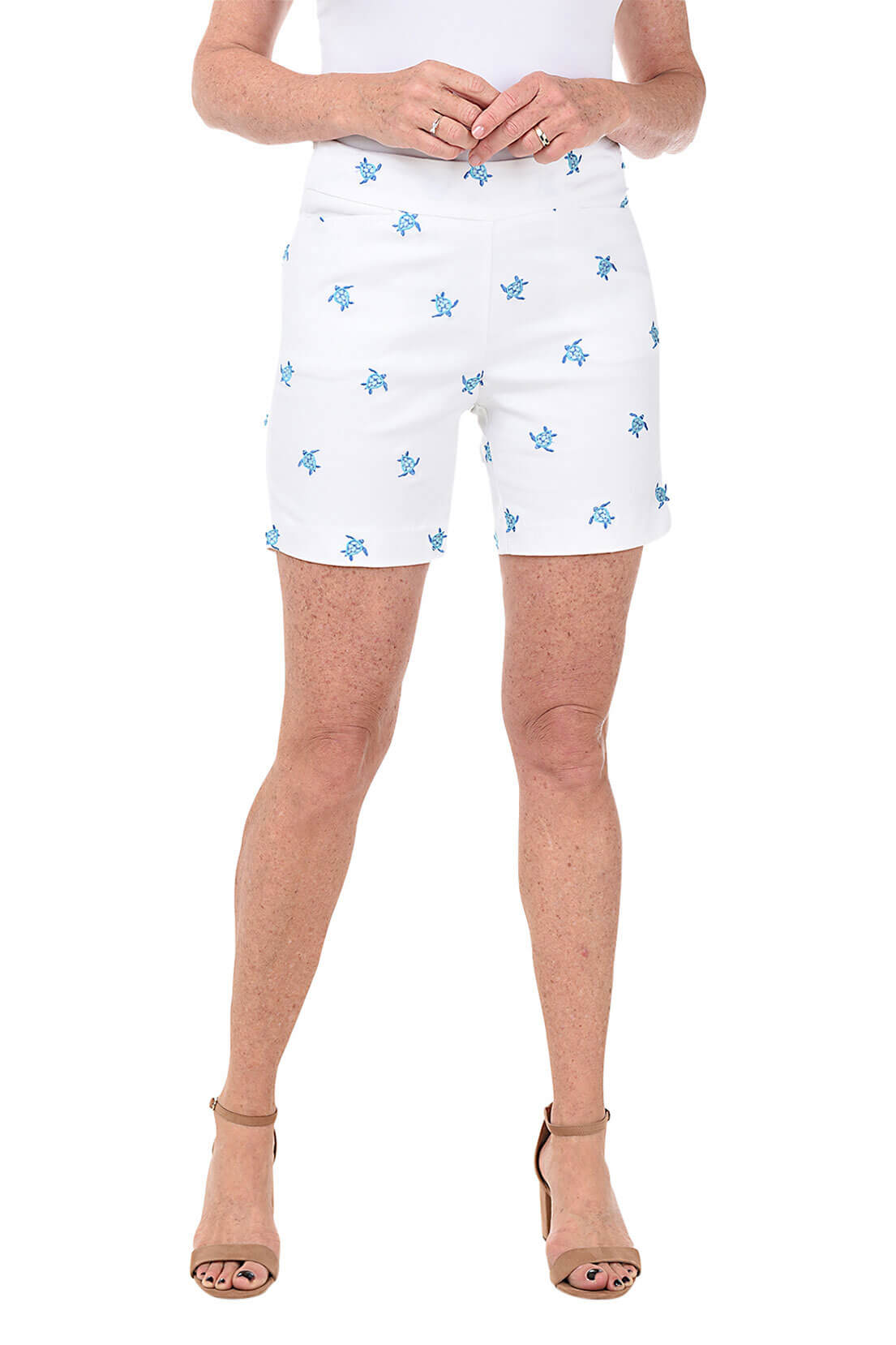 White shorts with blue turtle patterns worn by a person on a white background