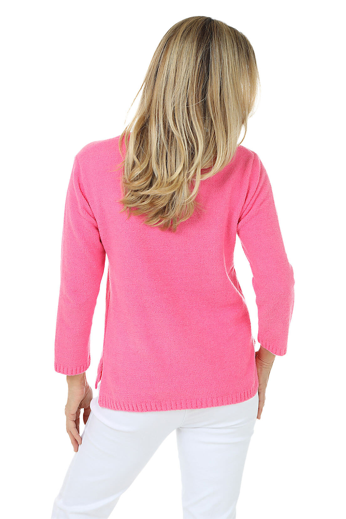 Woman wearing a pink sweater and white pants on a white background