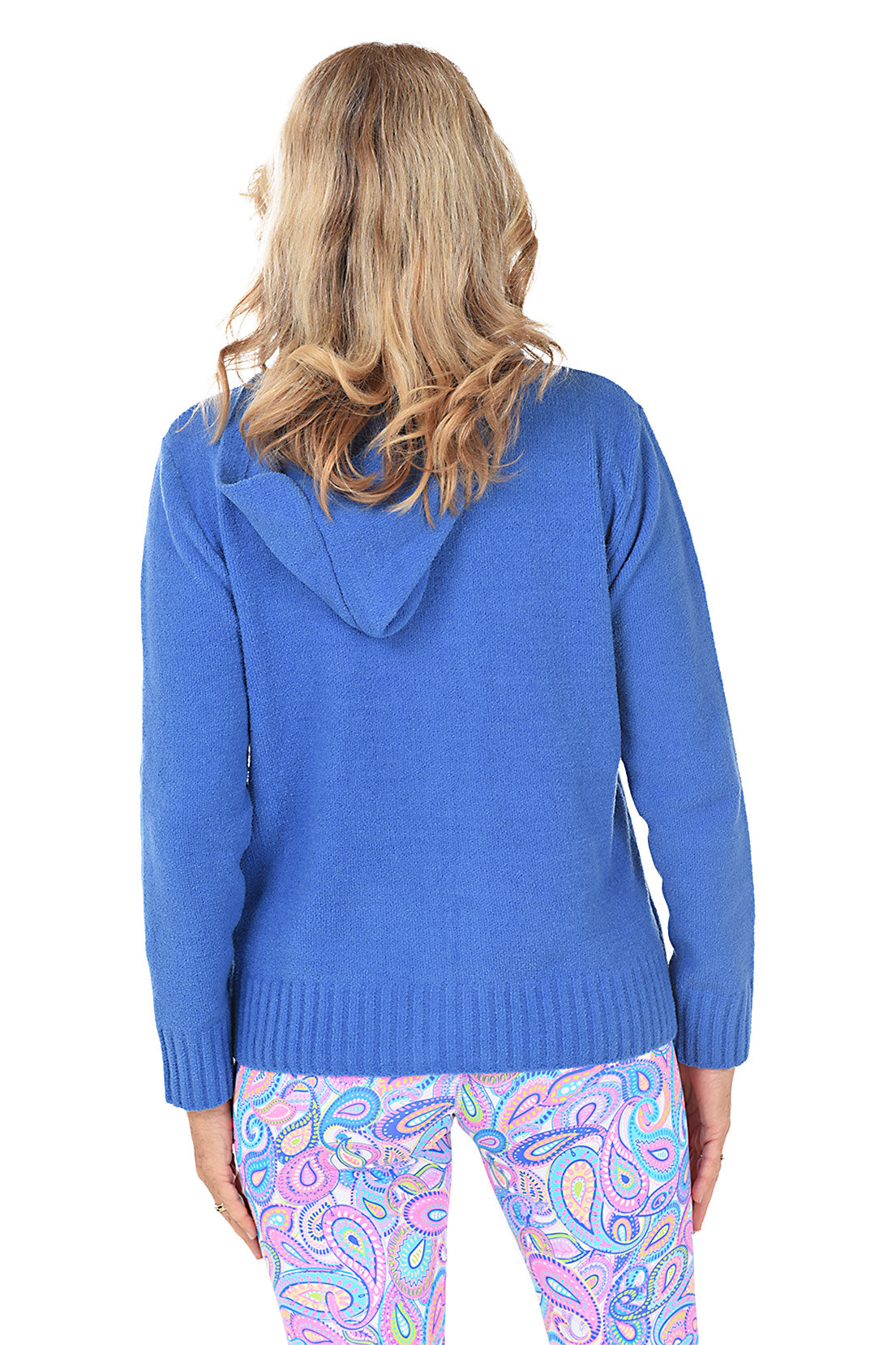 Woman wearing a blue zip-up hoodie and colorful patterned leggings on a white background. Back shot.