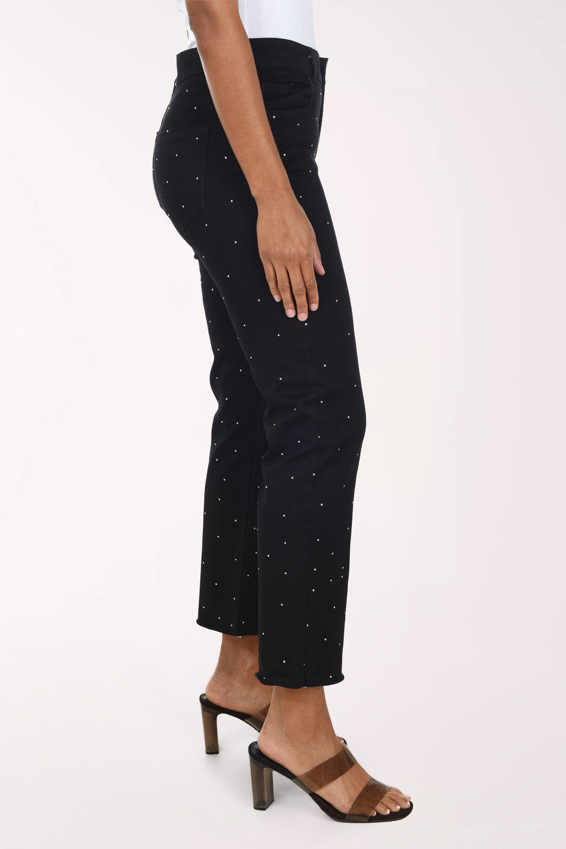 Woman wearing a black crop denim pant with all over jewels