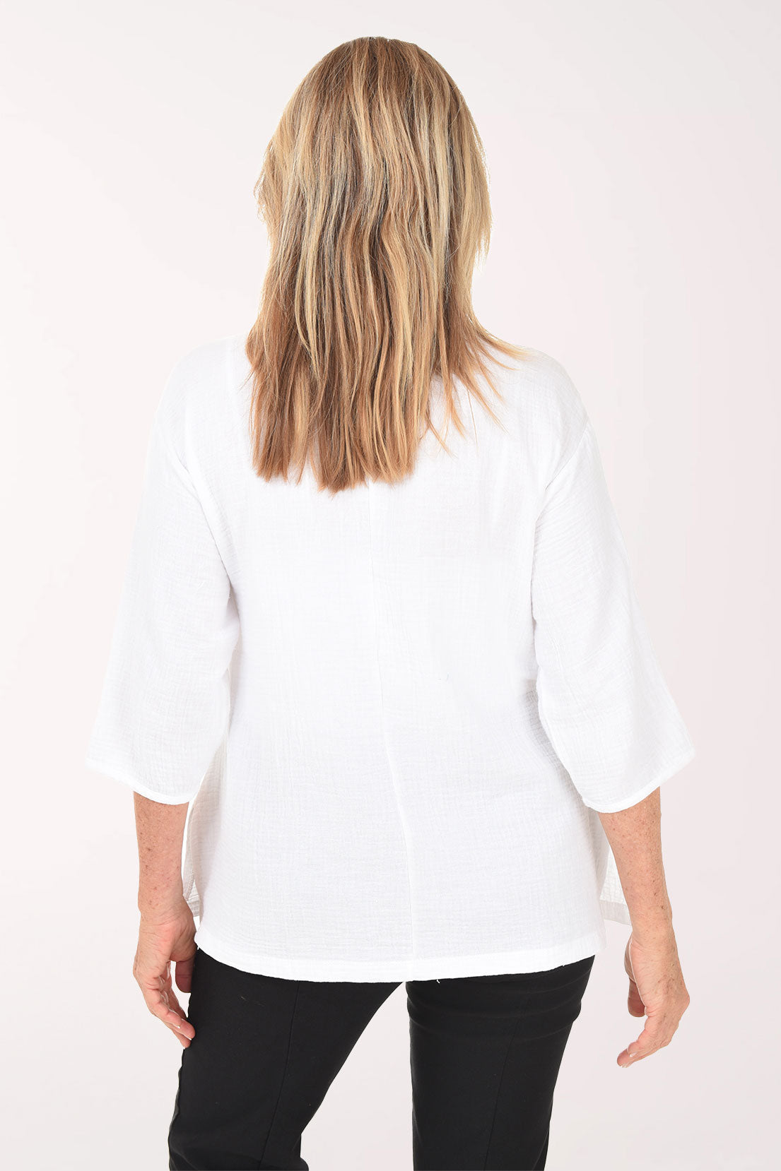 Woman wearing a white blouse with a plain background