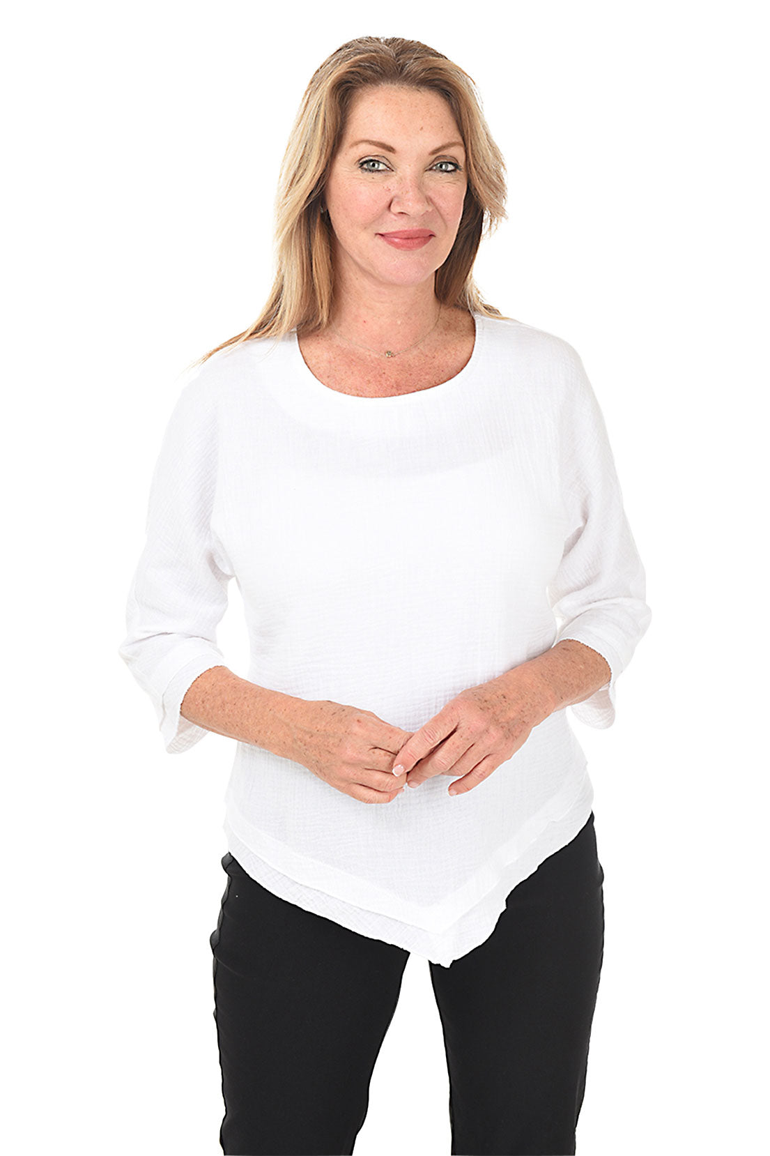 A woman wearing a white scoop neck blouse with 3/4 dolman sleeves and a pointed handkerchief hemline.