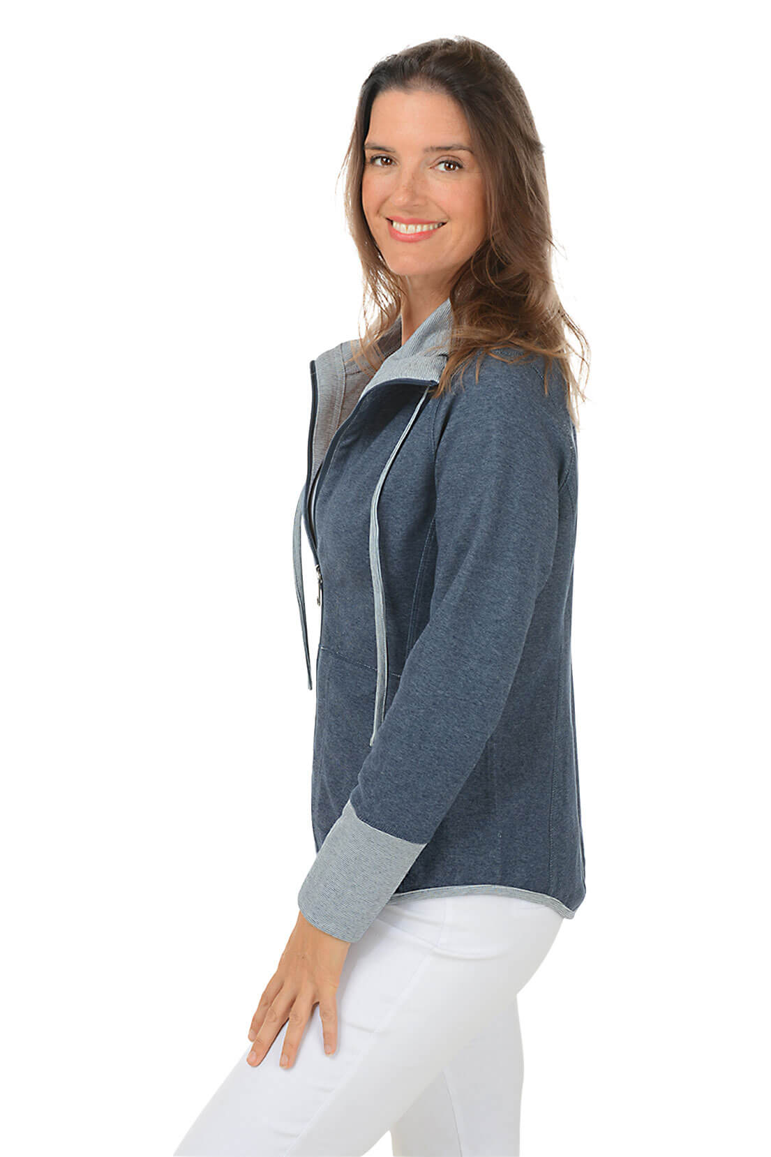 Woman wearing a blue zip-up hoodie with a white background. Side shot.