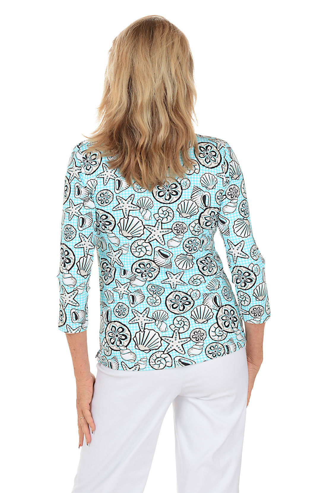 Woman wearing a blue top with shell pattern on a white background. Back shot.
