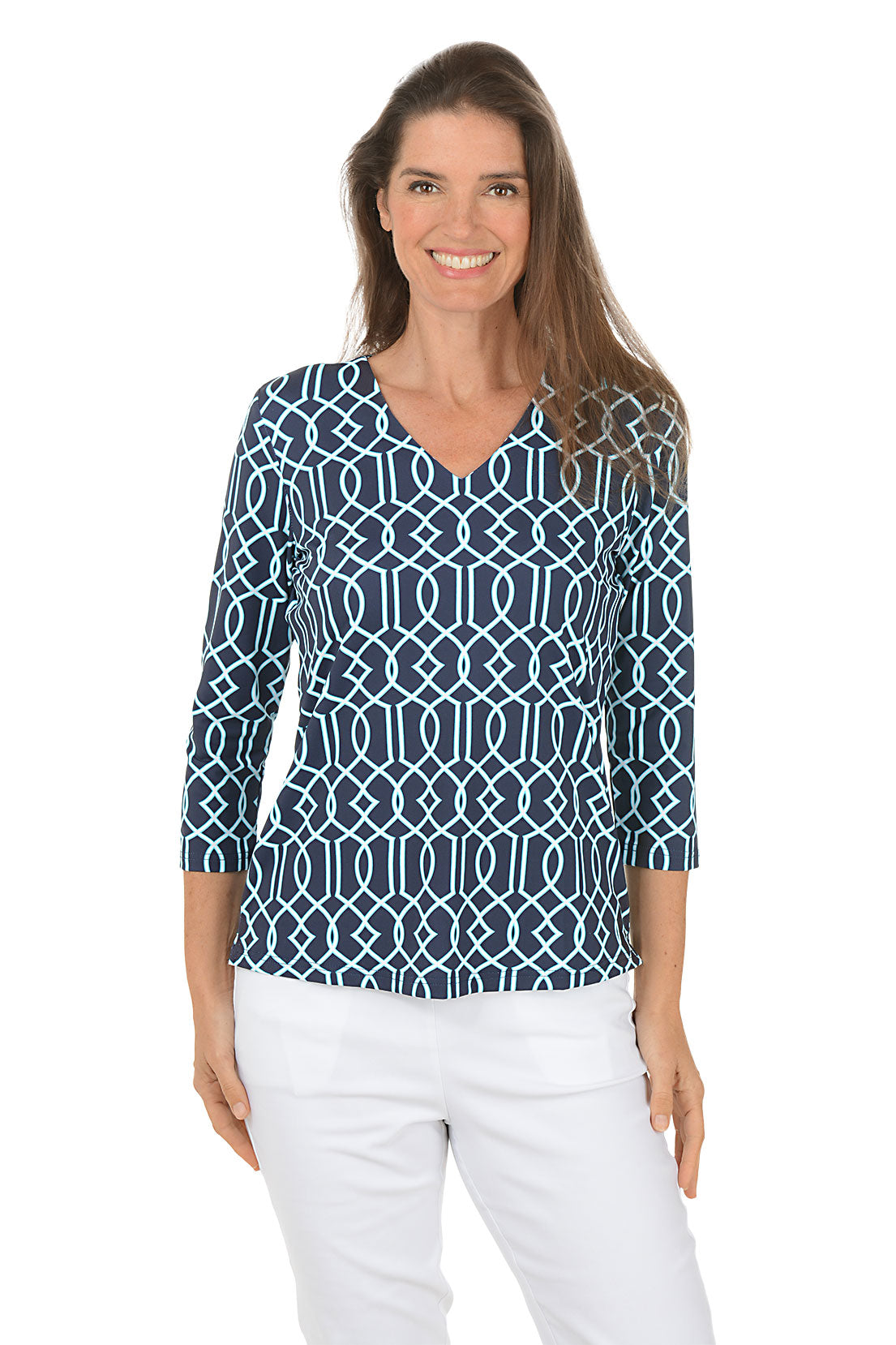 Woman wearing a blue patterned top and white pants on a white background. Second front shot.