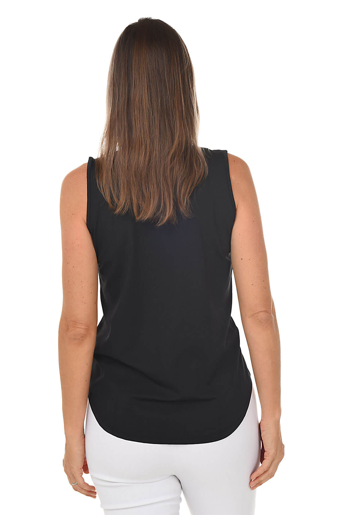 Woman wearing a black sleeveless top and white pants on a white background. Back shot.